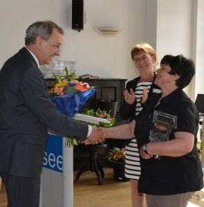 Blumen vom Staatssekretär: Hendrik Fischer beglückwünscht Carola Meißner aus Plessa zum 3. Platz „Einzelgeschichten“